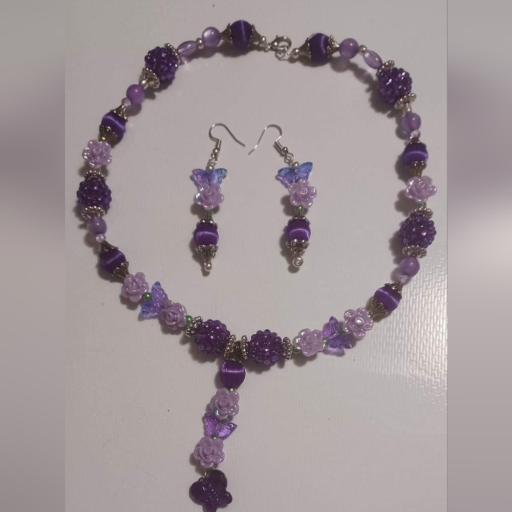 Hand crafted necklace and earrings set with a couple of color's of purple.